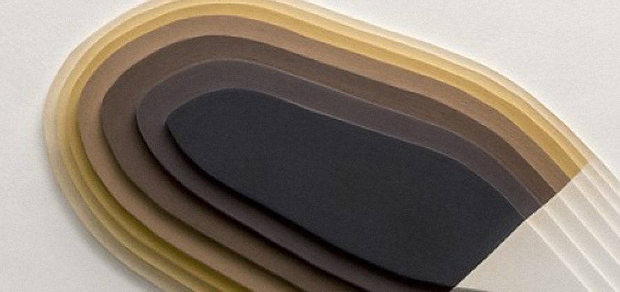 Layered paper relief in ochre and charcoal